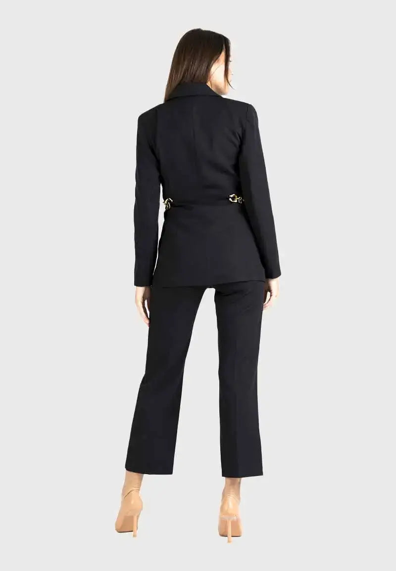 Women's suit consisting of a blazer, pants and gold chains on the sides