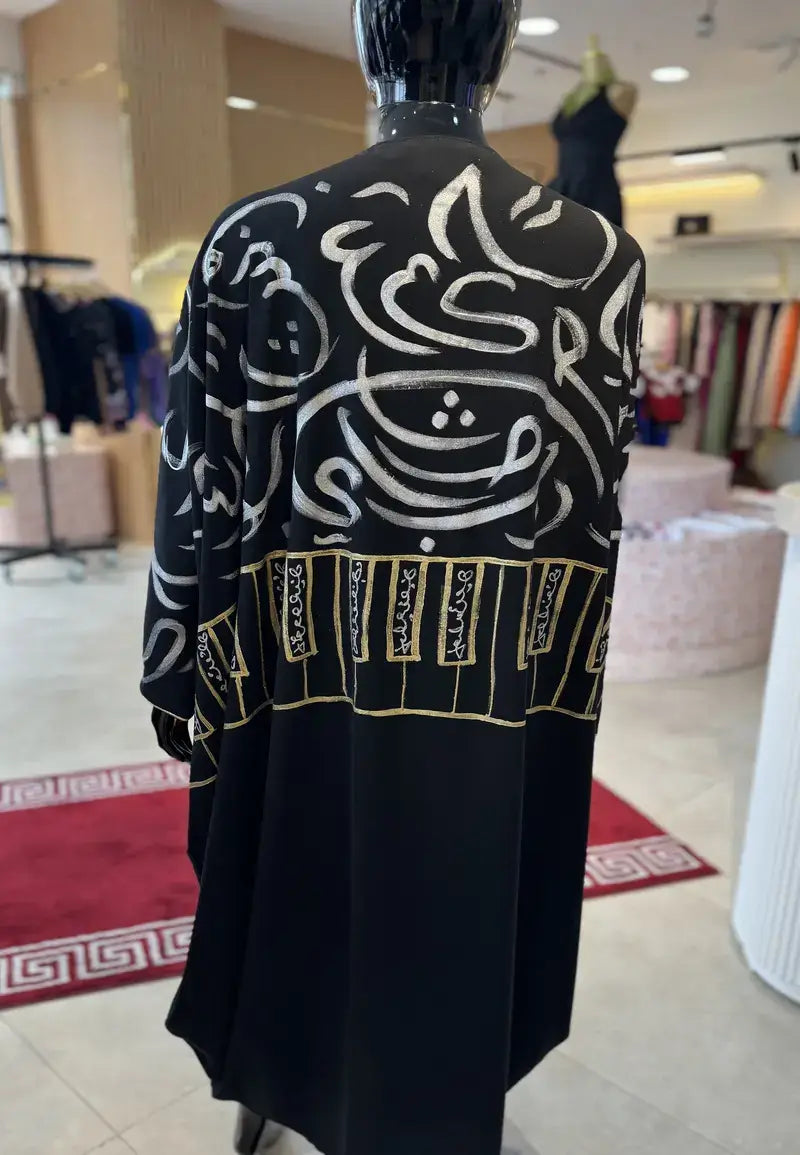 Luxurious black and white abaya embroidered with golden letters